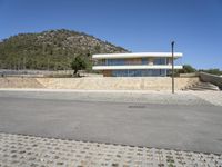 a large building with an open courtyard and paved walkways leading to it in front of a mountain