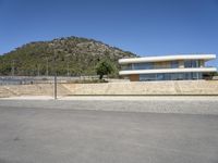 a large building with an open courtyard and paved walkways leading to it in front of a mountain