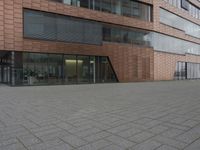 the fire hydrant is sitting near the building that looks very modern and contemporary,