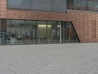 the fire hydrant is sitting near the building that looks very modern and contemporary,