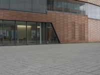 the fire hydrant is sitting near the building that looks very modern and contemporary,