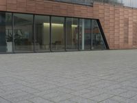 the fire hydrant is sitting near the building that looks very modern and contemporary,