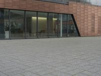 the fire hydrant is sitting near the building that looks very modern and contemporary,