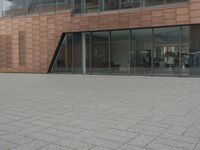 the fire hydrant is sitting near the building that looks very modern and contemporary,