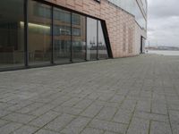 the fire hydrant is sitting near the building that looks very modern and contemporary,