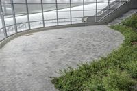 an open area with some plants next to it, and a wall and stairs and a bench with people