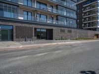 a man is riding a skateboard along the street in front of a building and glass windows