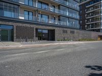 a man is riding a skateboard along the street in front of a building and glass windows