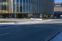 an empty street with buildings around it and a bus stop sign in front of the building