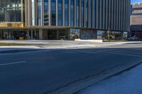 an empty street with buildings around it and a bus stop sign in front of the building