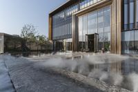 the entrance of a building is reflecting the water on the floor and walls, making smoke rising from the windows