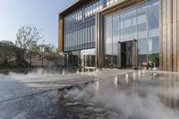 the entrance of a building is reflecting the water on the floor and walls, making smoke rising from the windows