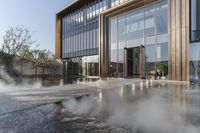 the entrance of a building is reflecting the water on the floor and walls, making smoke rising from the windows