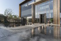 the entrance of a building is reflecting the water on the floor and walls, making smoke rising from the windows