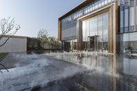 the entrance of a building is reflecting the water on the floor and walls, making smoke rising from the windows