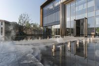 the entrance of a building is reflecting the water on the floor and walls, making smoke rising from the windows