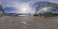 fisheye lens photograph of an architecture building on the edge of a road in front of other buildings