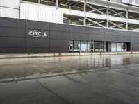 a building with a couple people in front of it under a grey sign that reads circle