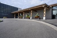 a large building with a bunch of plants inside of it and flowers in pots in the front