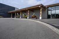 a large building with a bunch of plants inside of it and flowers in pots in the front