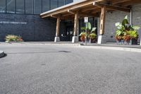 a large building with a bunch of plants inside of it and flowers in pots in the front