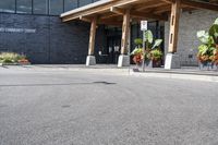 a large building with a bunch of plants inside of it and flowers in pots in the front