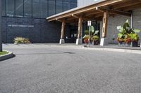 a large building with a bunch of plants inside of it and flowers in pots in the front