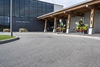 a large building with a bunch of plants inside of it and flowers in pots in the front