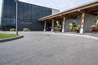 a large building with a bunch of plants inside of it and flowers in pots in the front