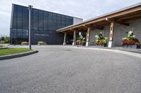 a large building with a bunch of plants inside of it and flowers in pots in the front