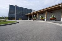 a large building with a bunch of plants inside of it and flowers in pots in the front