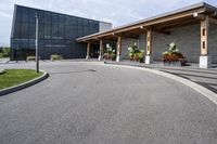 a large building with a bunch of plants inside of it and flowers in pots in the front