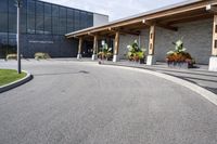 a large building with a bunch of plants inside of it and flowers in pots in the front