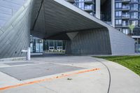 a building with two large windows on the side of it, and a walkway below with a fire hydrant outside