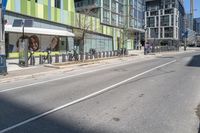 a street with buildings that are painted green and white on it's sides and side of the road