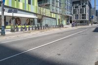 a street with buildings that are painted green and white on it's sides and side of the road