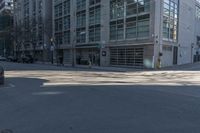 the view of a cross walk across the road from a building and in between two parked cars