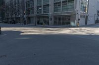 the view of a cross walk across the road from a building and in between two parked cars