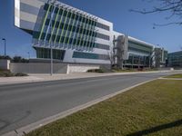 the office building is on a corner near the road that leads to a parking lot