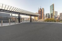 an empty parking lot with buildings in the background with a skate board attached to a ramp