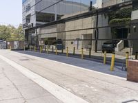 a sidewalk with benches on it and a building reflecting in the glass back wall and windows