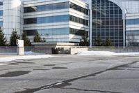 the building is next to a garbage can and snow on the ground area of the courtyard