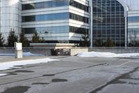 the building is next to a garbage can and snow on the ground area of the courtyard