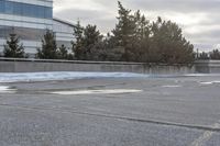 the building is next to a garbage can and snow on the ground area of the courtyard