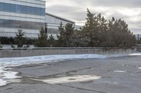 the building is next to a garbage can and snow on the ground area of the courtyard