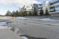 the building is next to a garbage can and snow on the ground area of the courtyard