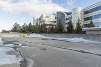 the building is next to a garbage can and snow on the ground area of the courtyard