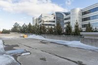 the building is next to a garbage can and snow on the ground area of the courtyard