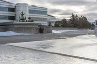 the building is next to a garbage can and snow on the ground area of the courtyard