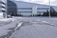 a street sign is sitting in the middle of an empty parking lot outside a building